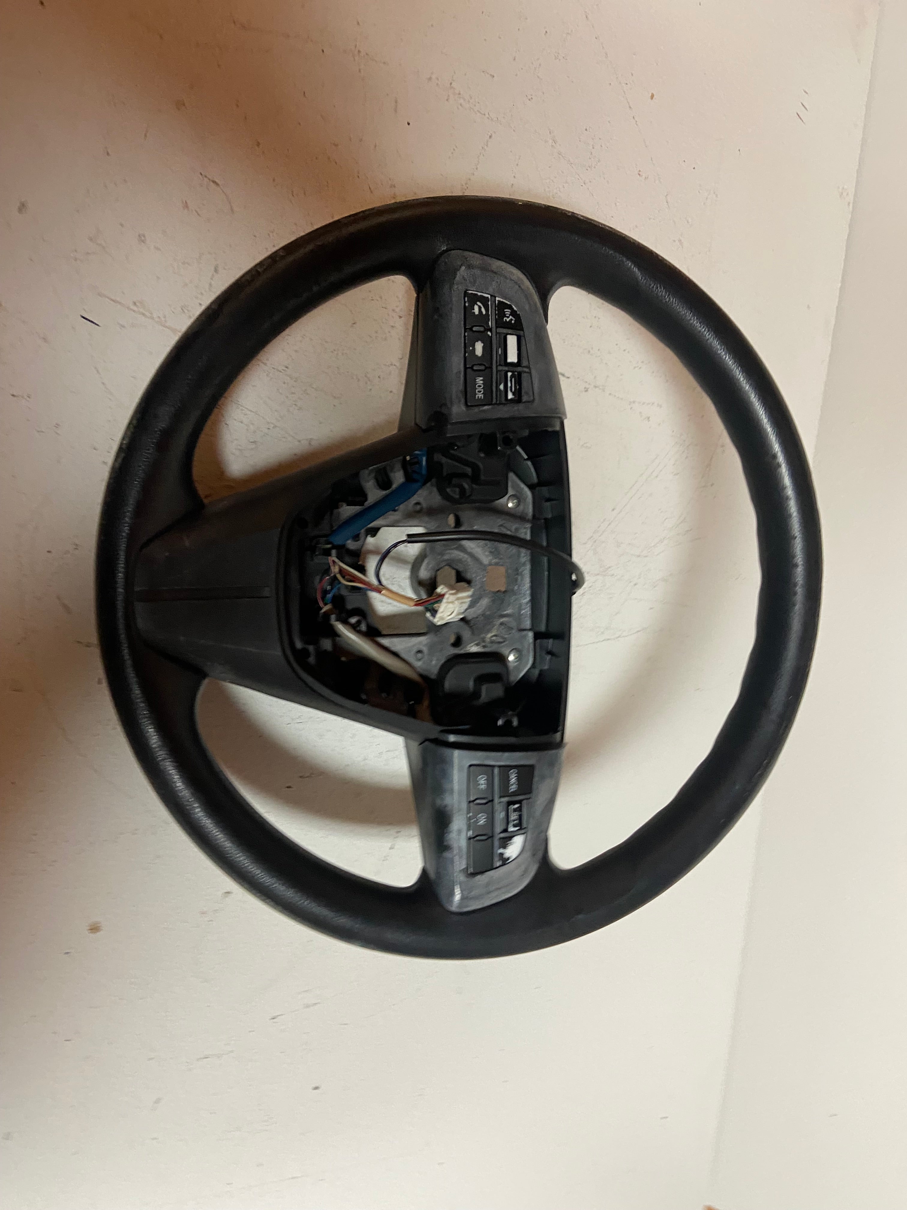 Black OEM steering wheel for 2010 Mazda 3 touring, close rear view with wiring and buttons
