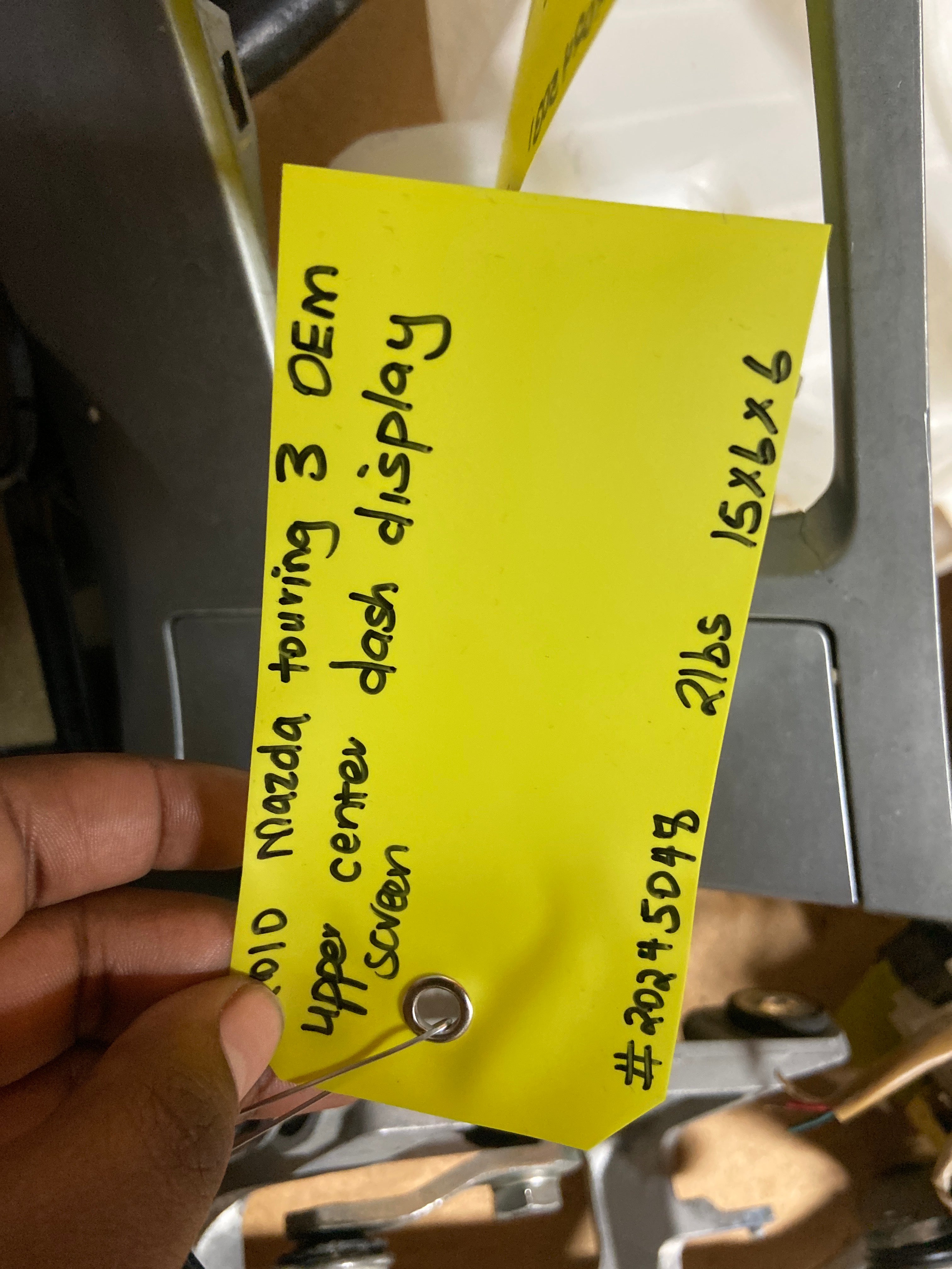 Black dash display screen module with attached yellow label tag