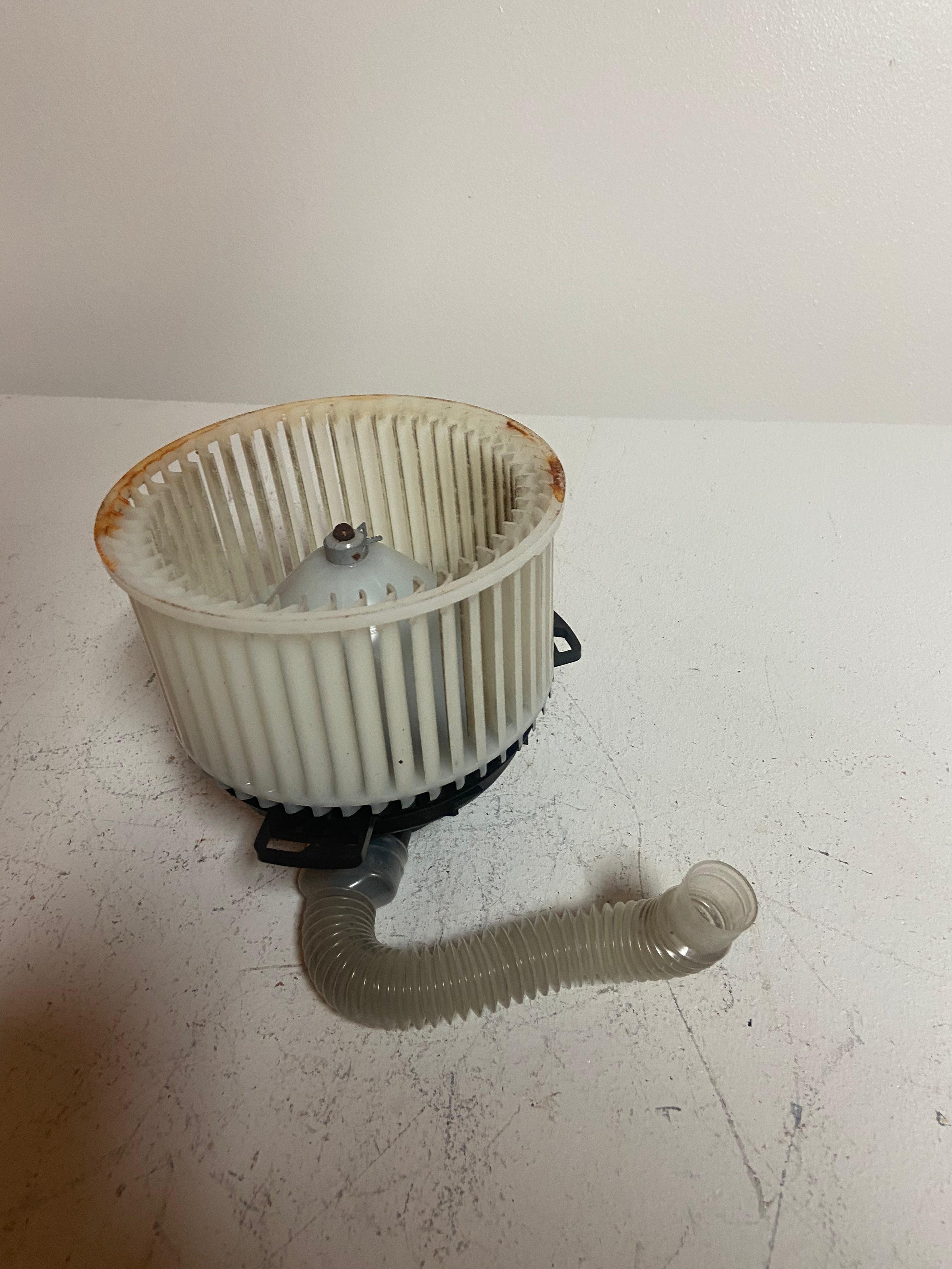 A/C heater blower motor with white fan wheel and corrugated hose