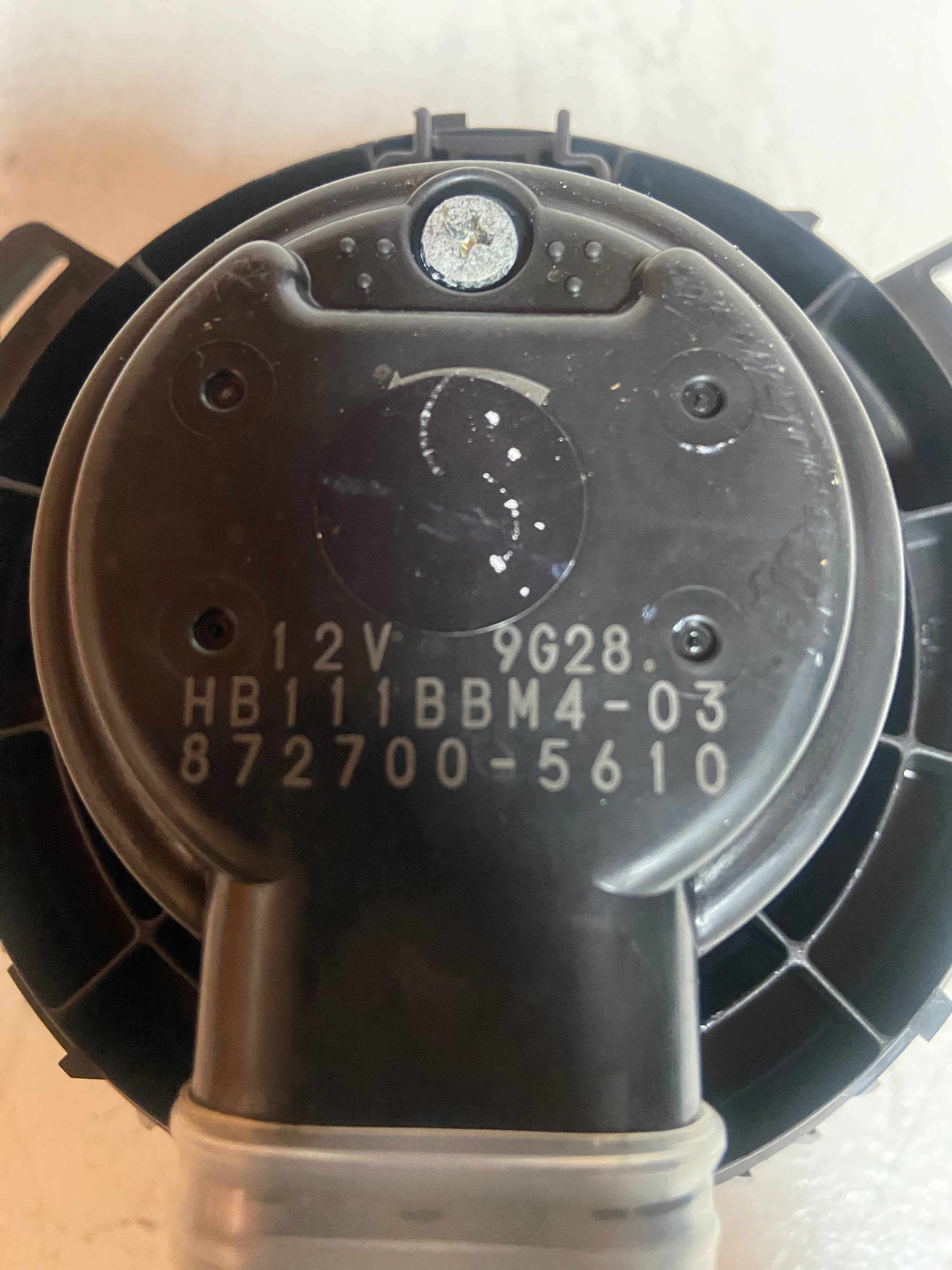 A/C heater blower motor housing with printed voltage and part numbers